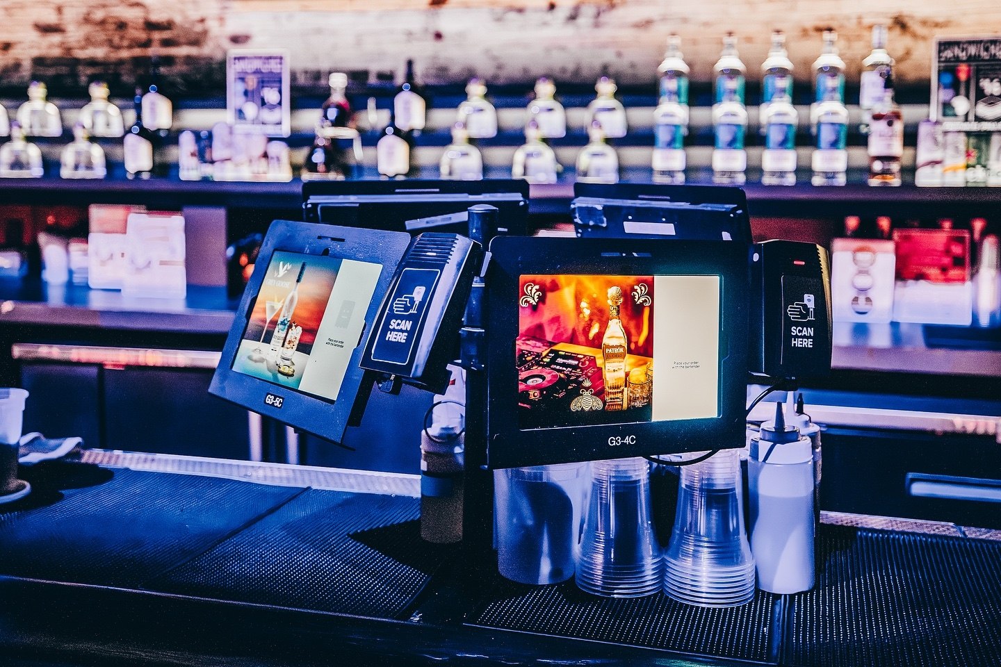 Two Billfold POS stations on a bar at night, each with a bartender screen and a guest screen back to back